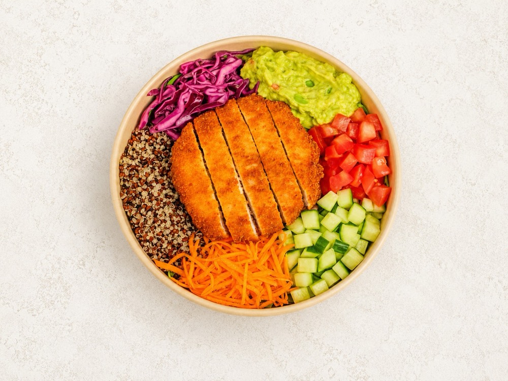 Bowl de pollo apanado con quinua tricolor, guacamole, col morada, pepino, tomate y zanahoria rallada